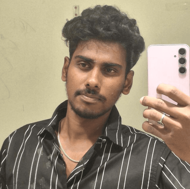 Young man with curly hair and mustache taking a mirror selfie with a pink smartphone.